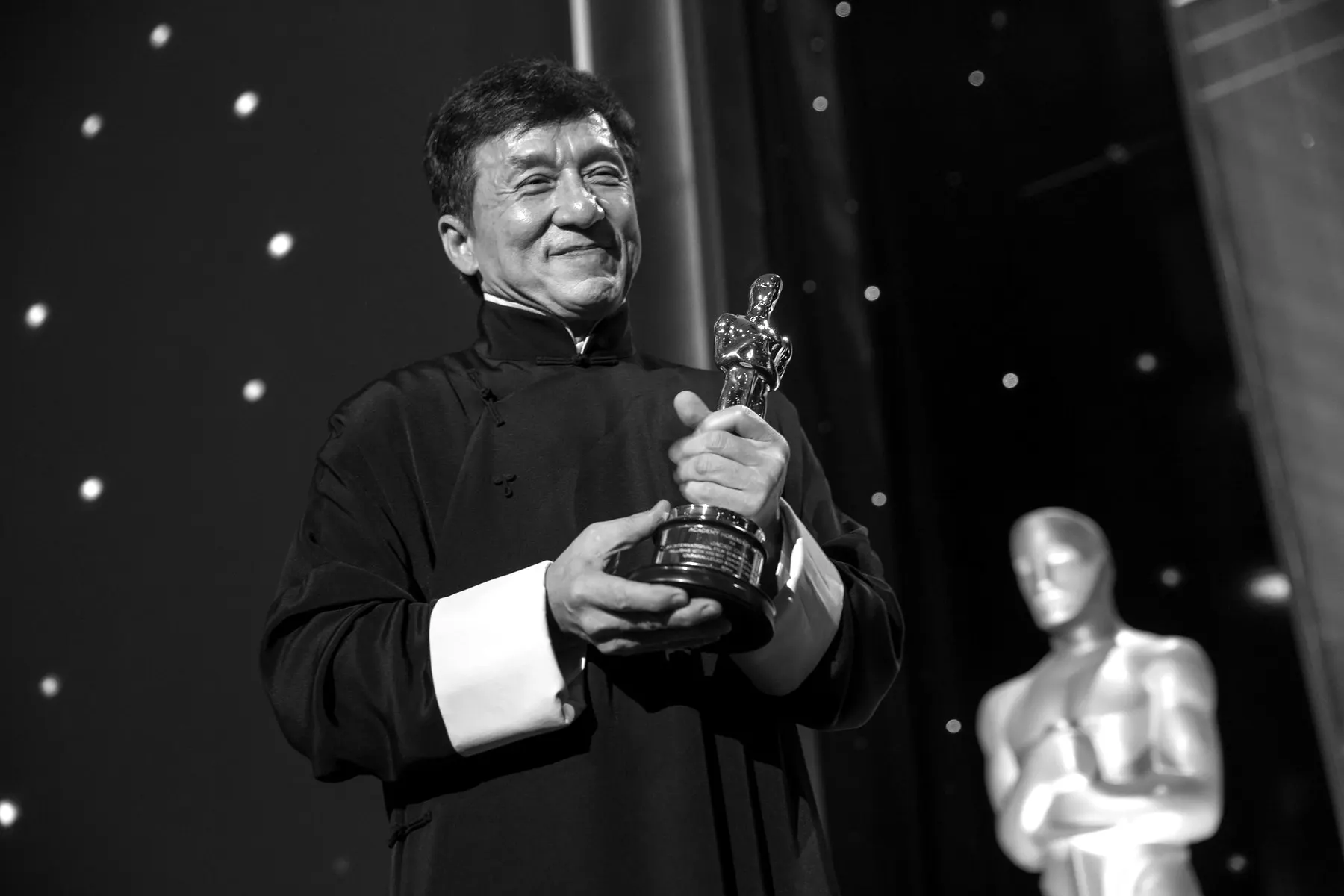 Jackie Chan holding his honorary Oscar
