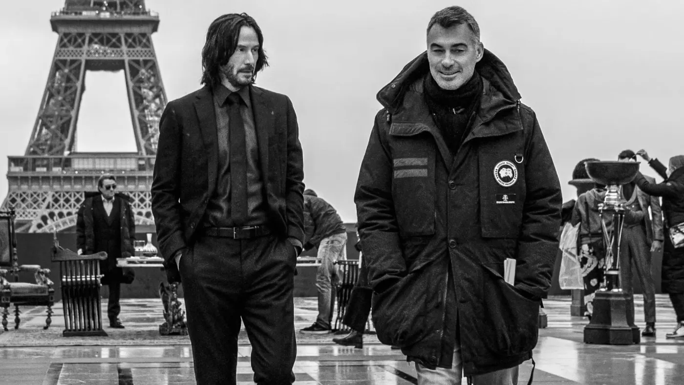 Chad Stahelski and Keanu Reeves walking on set in front of the Eiffel Tower
